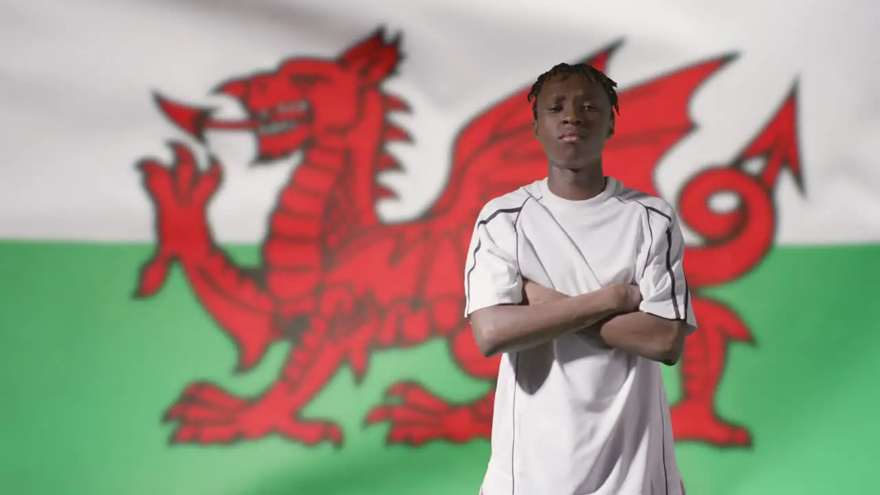 Young Footballer Walking to Camera In Front of Wales Flag 02