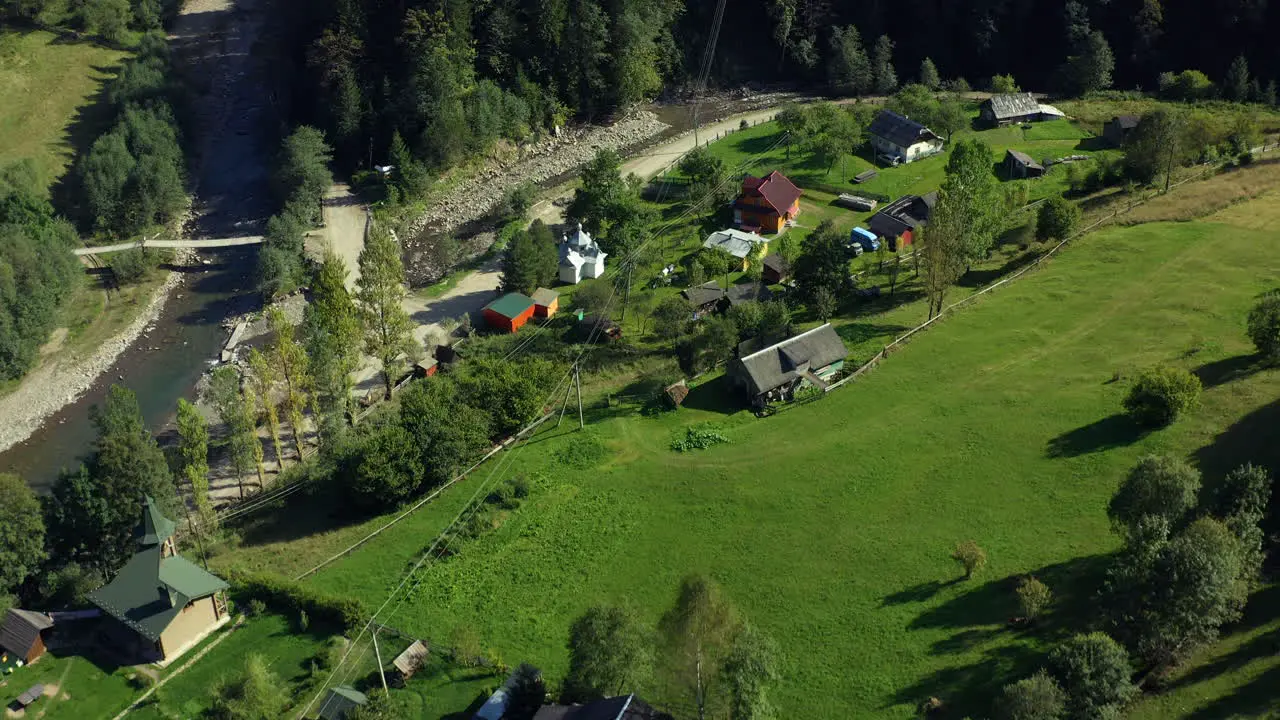 Small rural village surrounded by green grass fields valley