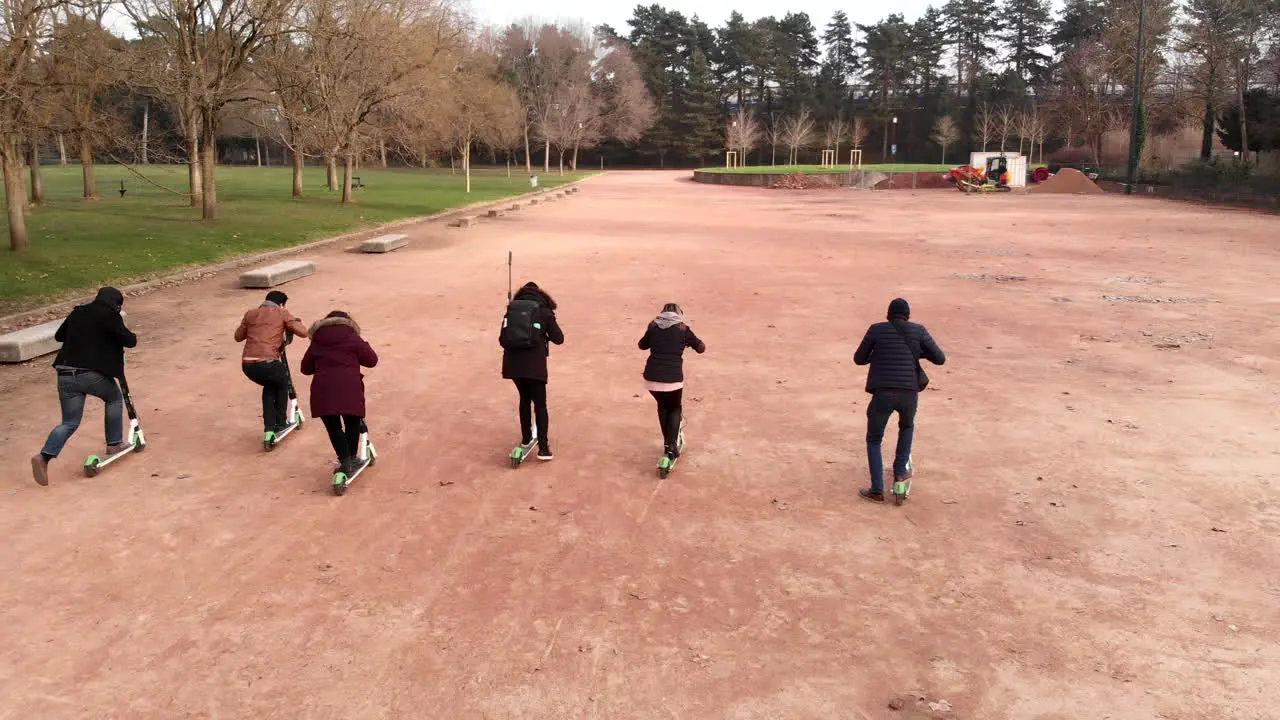 A group of friends doing a drag race with electric scooters