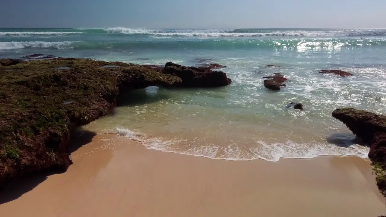 Stable 4k view of Uluwatu Beach in Bali Indonesia sand and waves rolling in