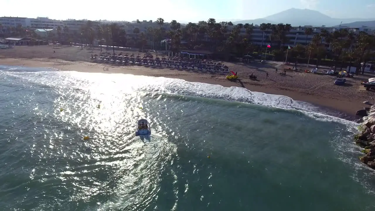 small boat coming to shore during a sunset filmed from drone in 4k in marbella malaga spain