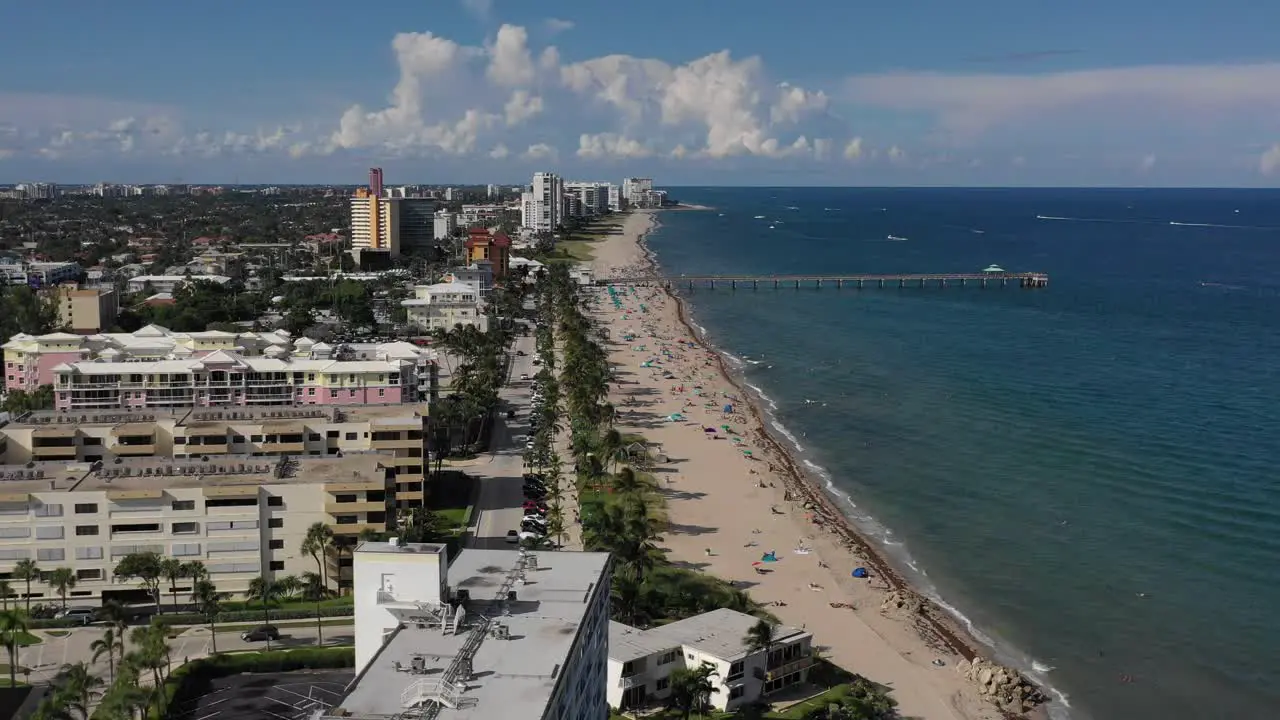 aerial following buildings on the coastal side of a beach