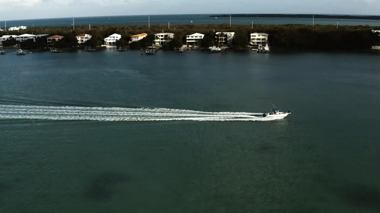 Aerial video of a small boat driving along the coast of key largo at various angles