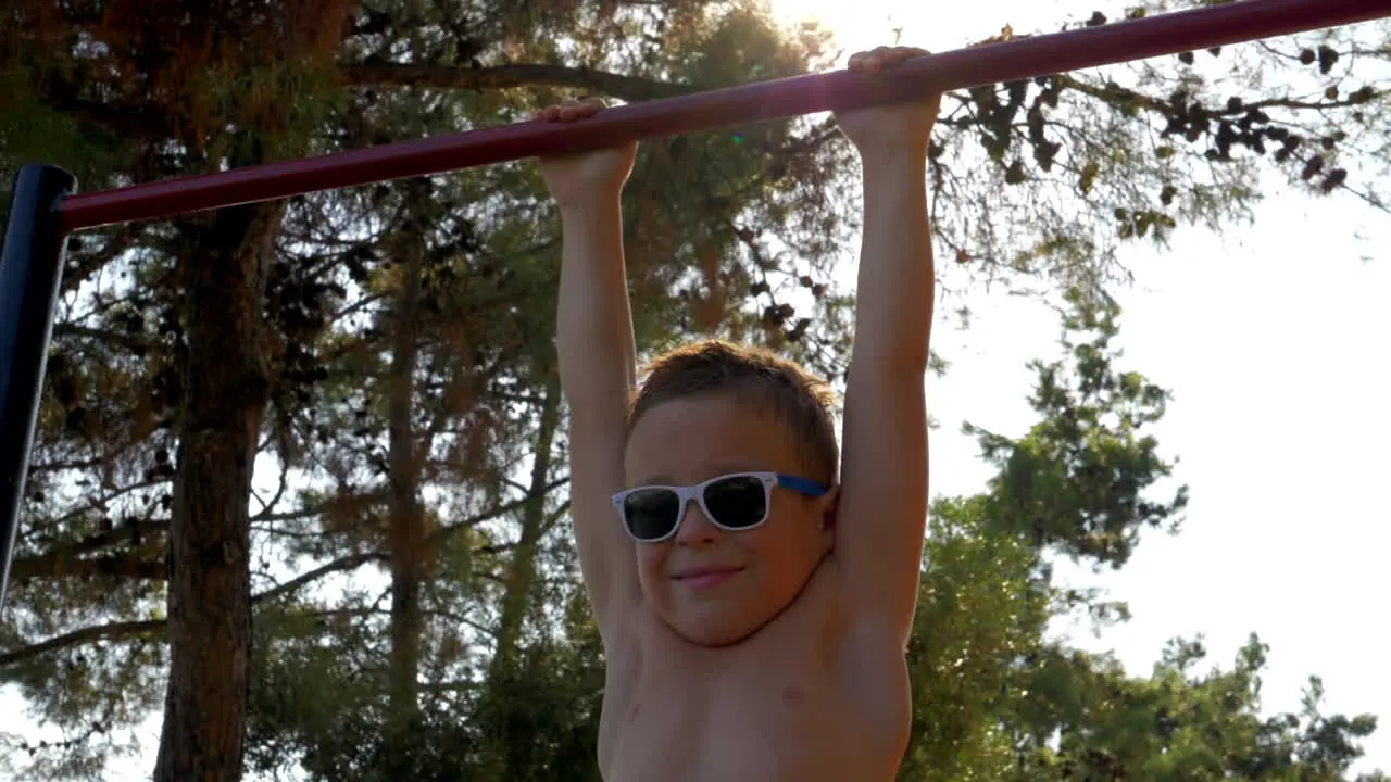 Child on pull-up bar at sports ground outdoor