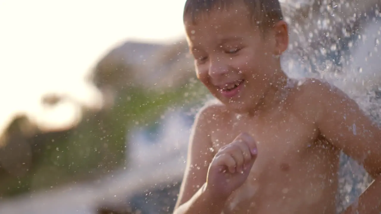 Happy kid enjoying cool beach shower and having fun