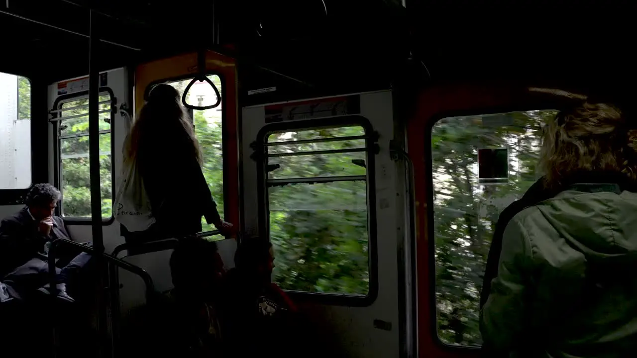 Passengers Inside Funicular Travelling Past Trees In Naples