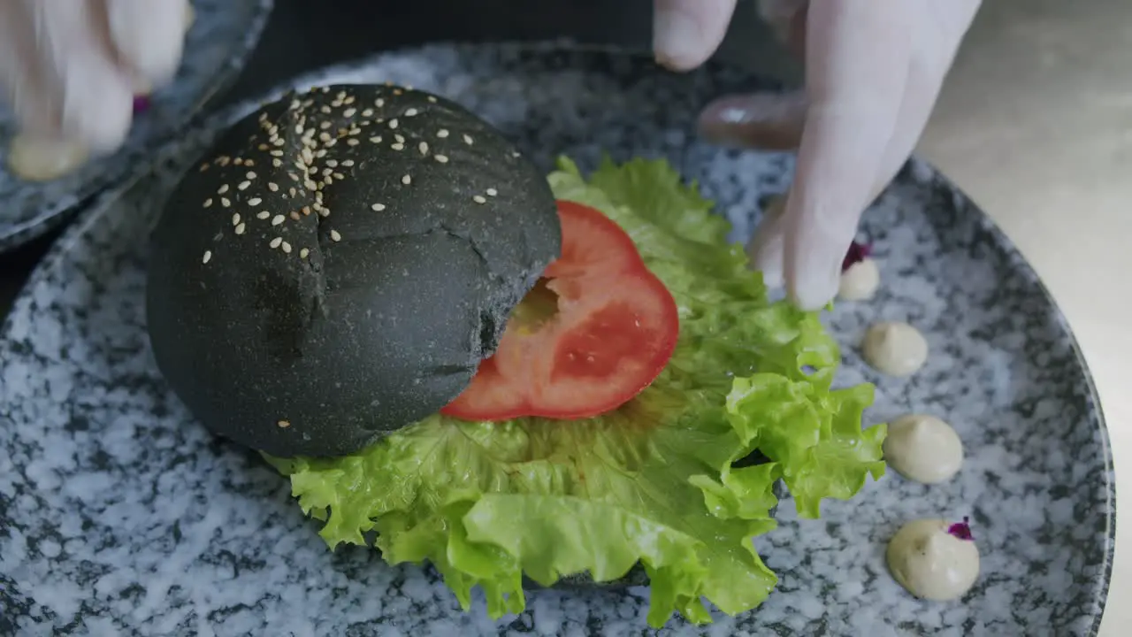 A professional chef is preparing a hamburger in his kitchen 02