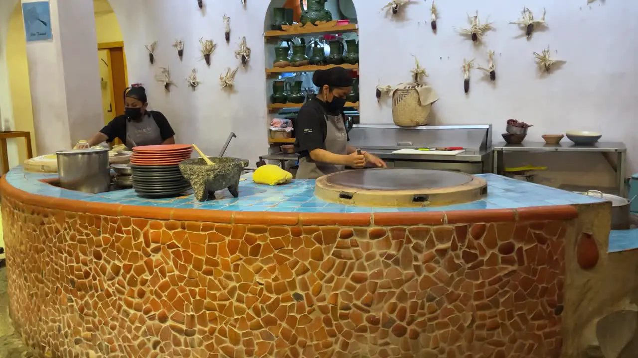 couple of cooks making tortillas on a griddle in oaxaca