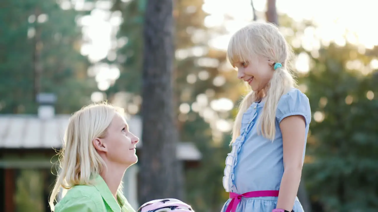 Mom Puts On A Protective Helmet For Her Daughter Concept Care And Safety Hd Video