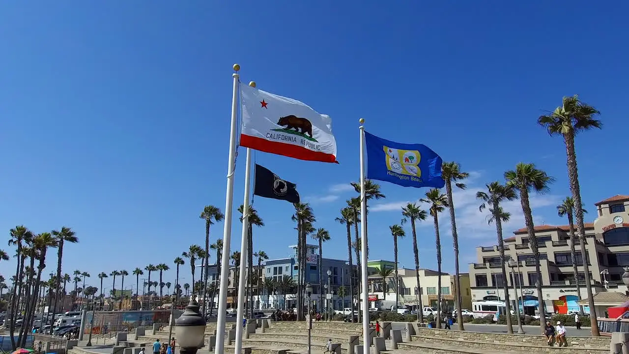 slow motion footage of the California state flag MIA-POW flag and the Huntington Beach City flag flying in Huntington Beach California