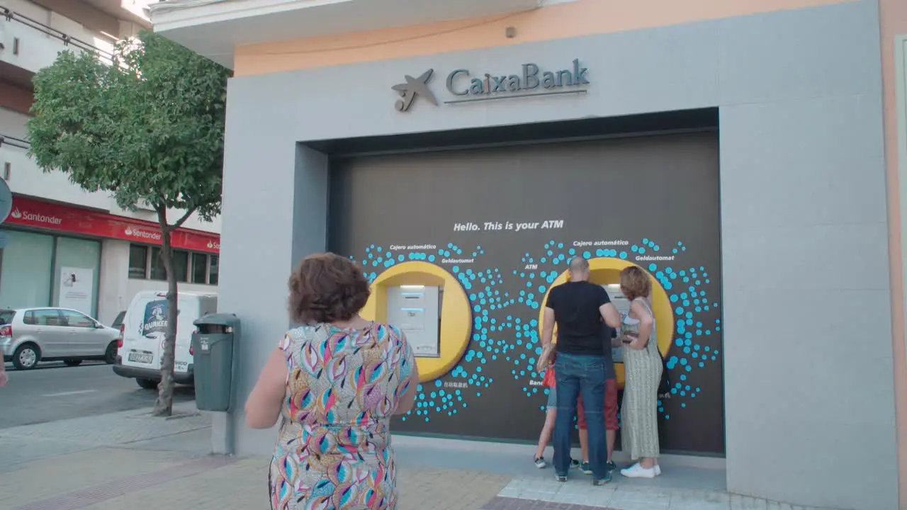 People using ATM at La Caixa Bank in Seville Spain Slow Motion