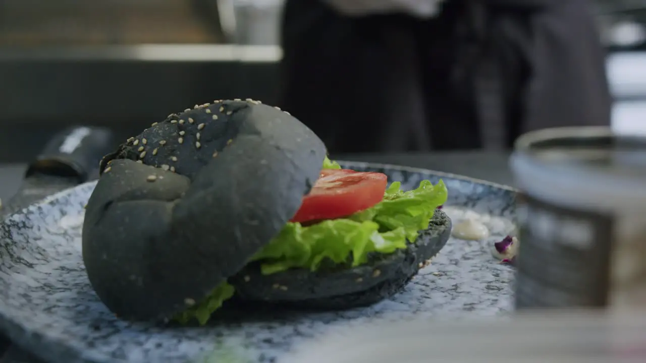 A professional chef is preparing a hamburger in his kitchen 04