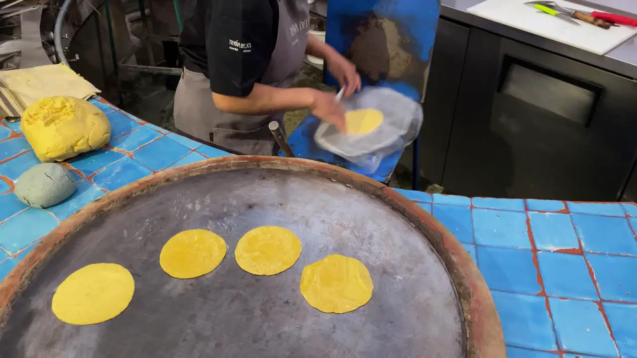 slow motion shot of a person preparing tortillas on a griddle in Oaxaca