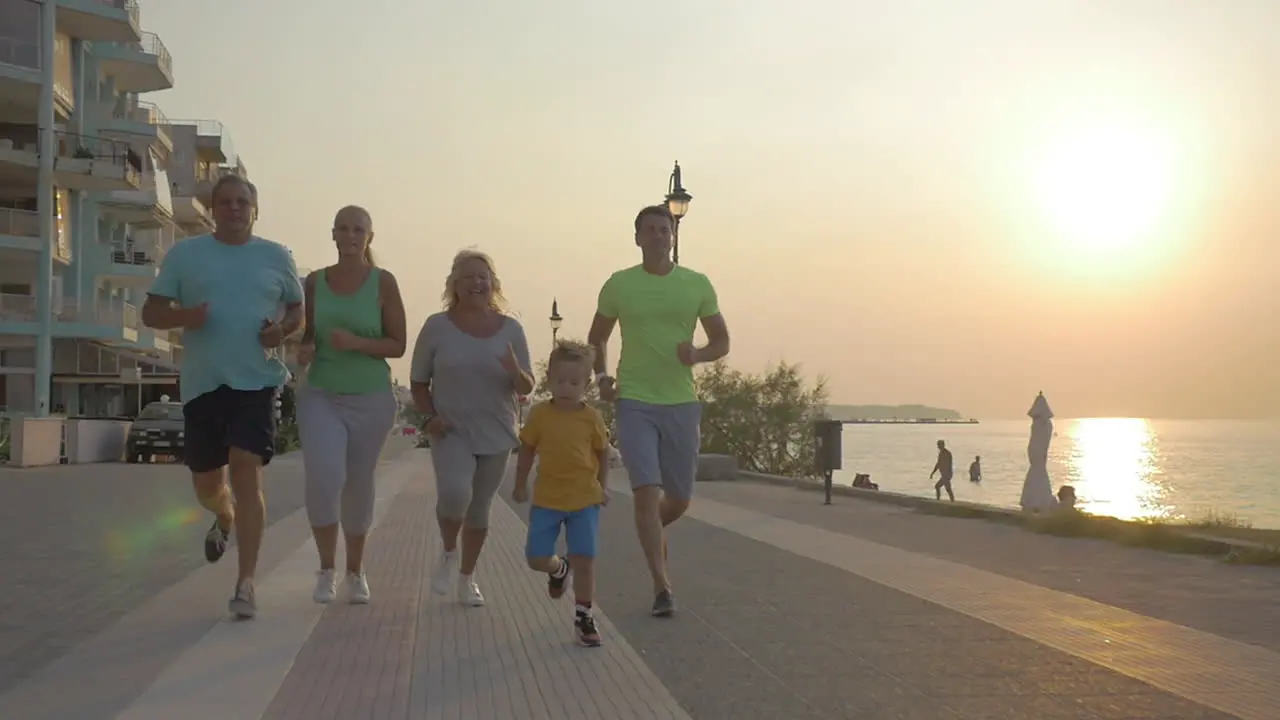 Friendly family running to finish on the pavement at sunset