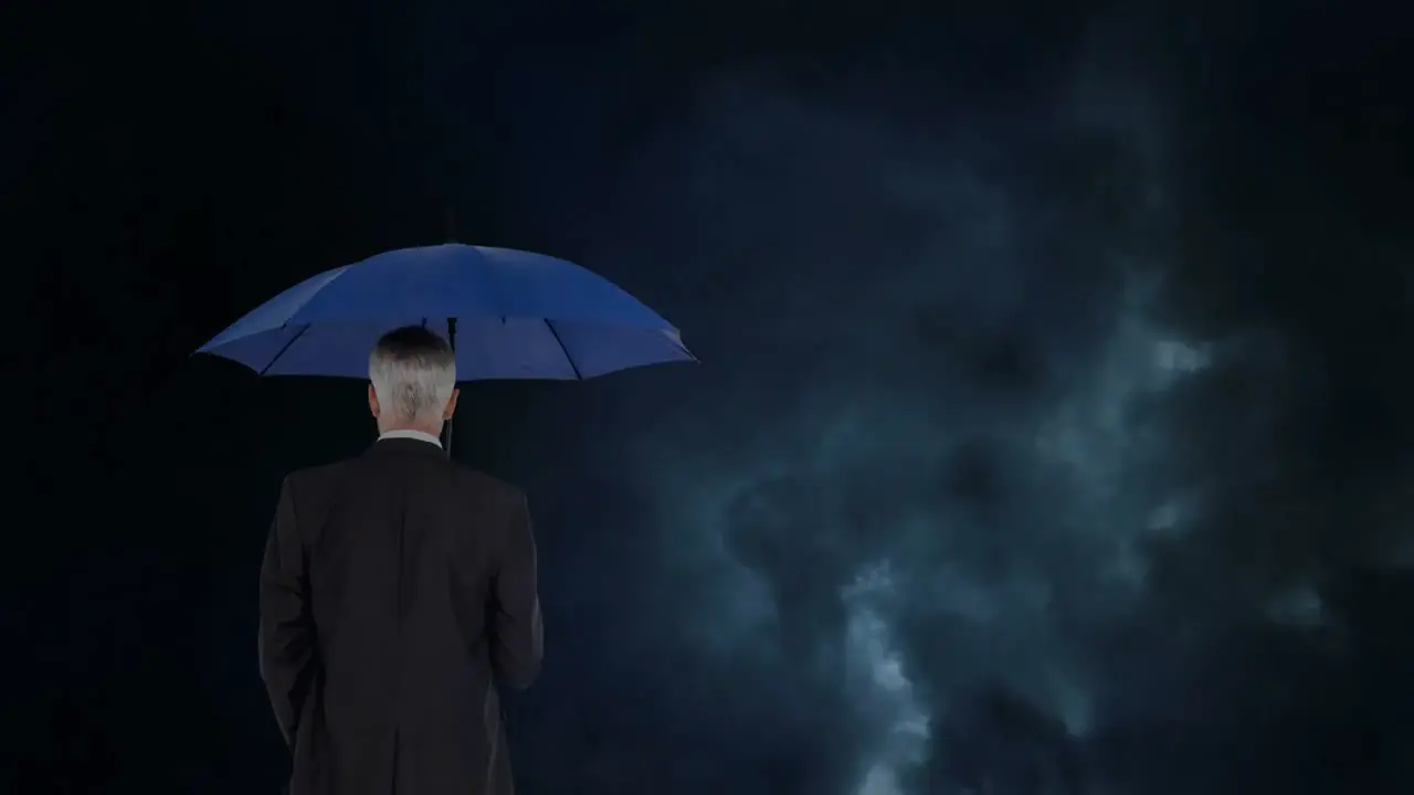 Businessman with umbrella during thunder