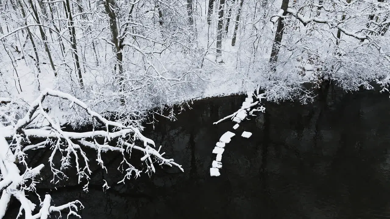 Drone footage gracefully gliding over the frosty banks of the snow-covered Huron River Valley