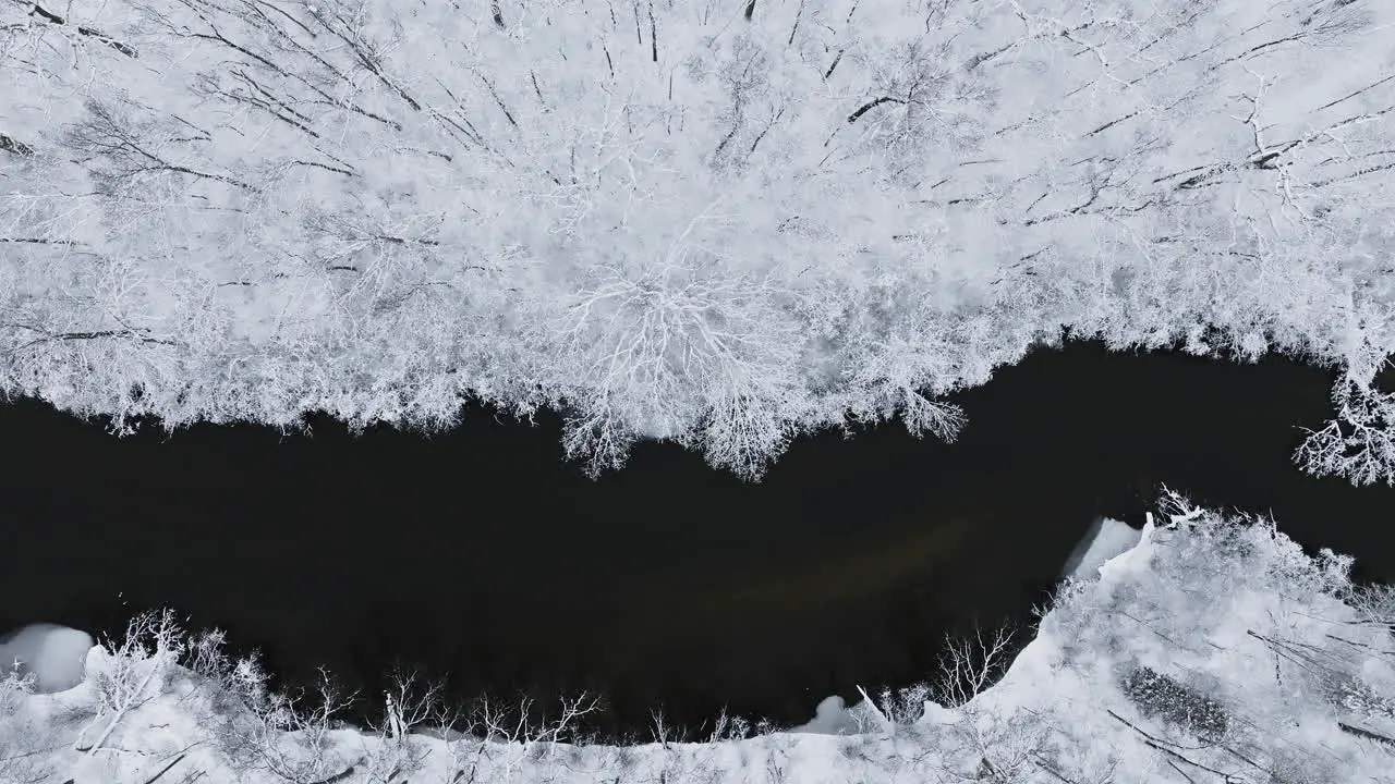 Aerial footage gliding above the snow-draped expanse of the Huron River Valley