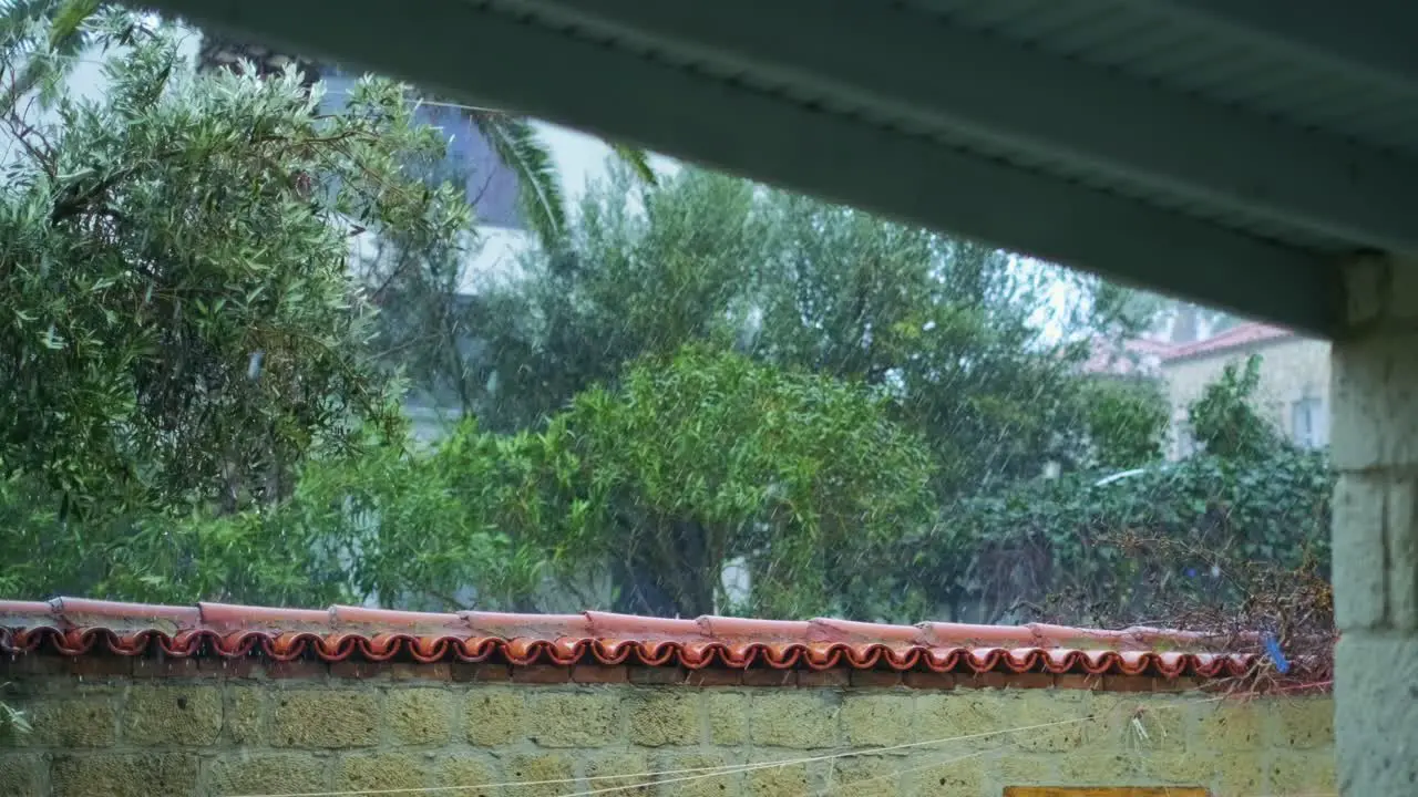 Heavy rain falling down on the roof of the patio