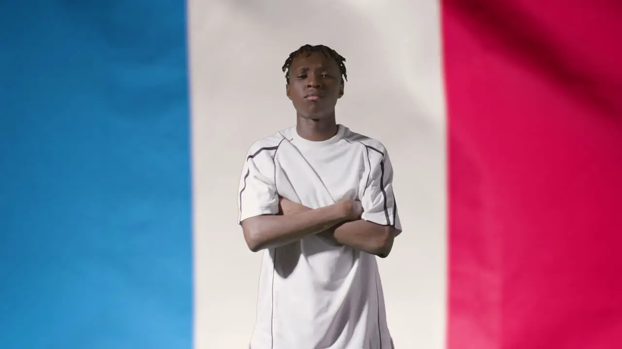 Young Footballer Walking Holding Football In Front of France Flag 