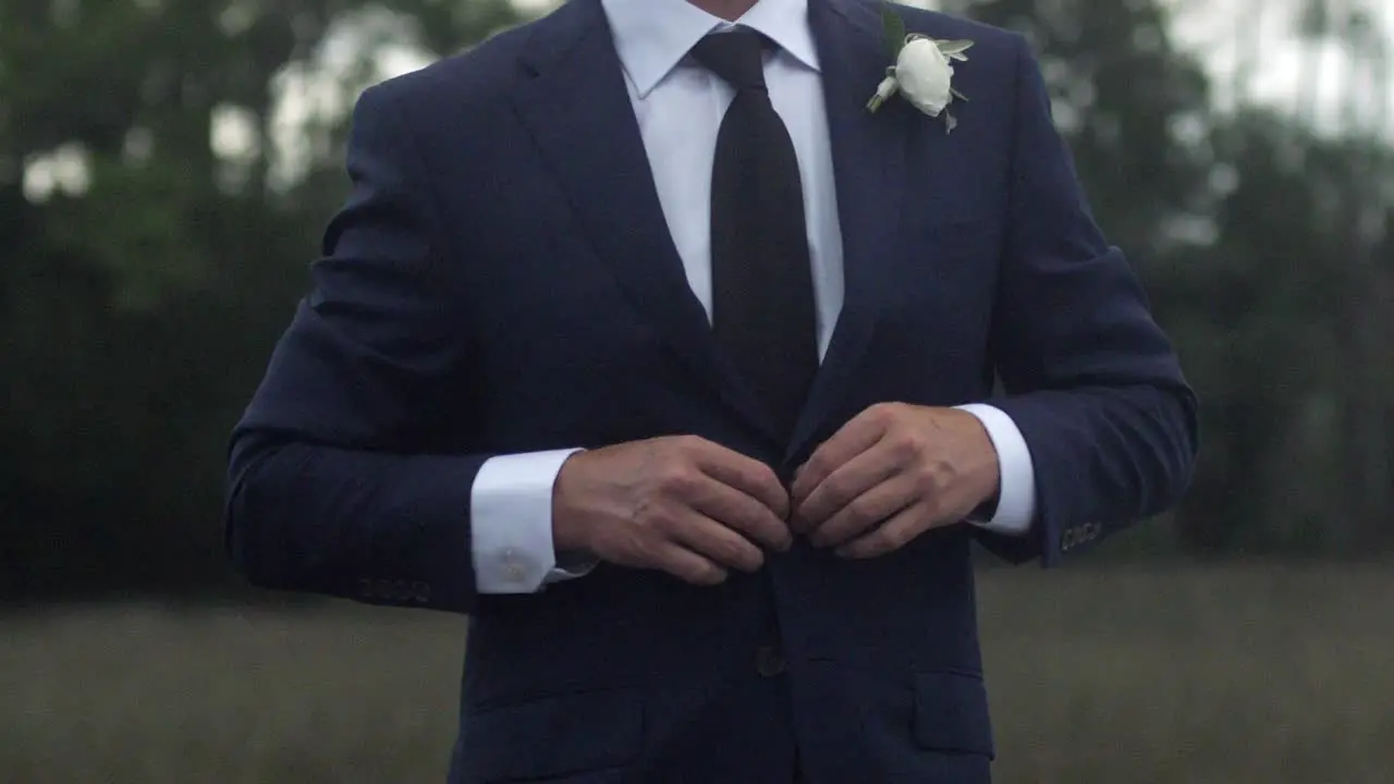 Man buttoning suit jacket slow motion