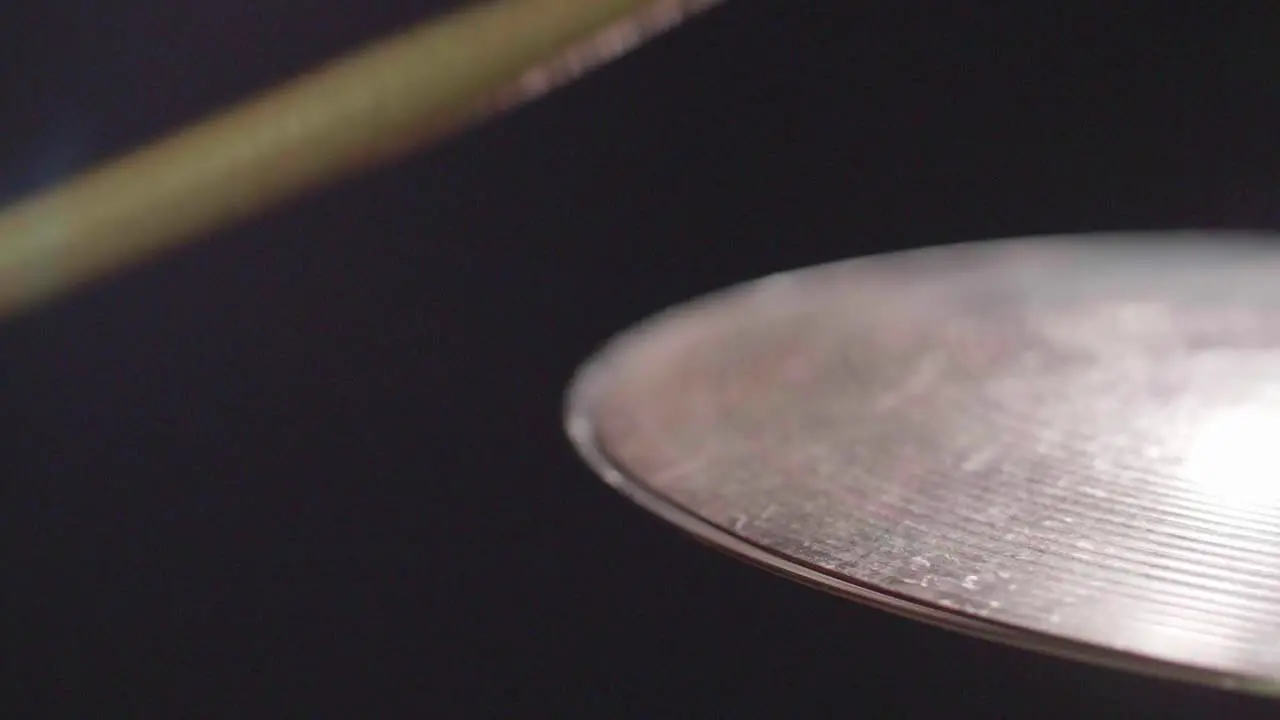 Smooth close up of a shiny drum hi-hat being played with sticks