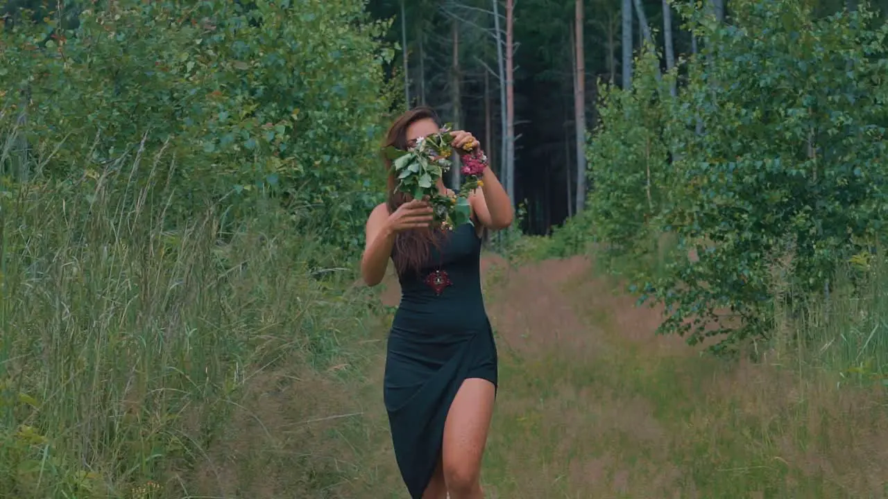 Pretty Lady Brushes Hair With Hand Then Puts Back Fresh Flower Headdress In The Tranquil Forest Of Olomouc In Czech Republic close up slow motion