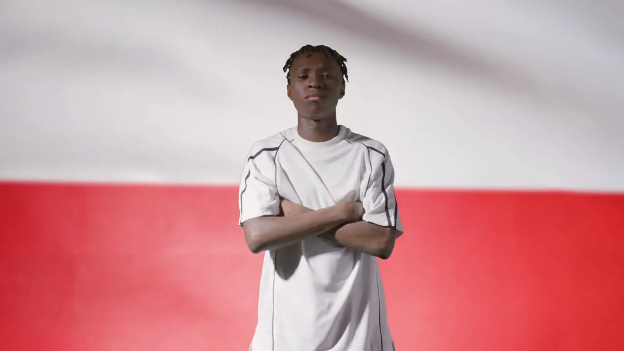 Young Footballer Walking to Camera In Front of a Poland Flag