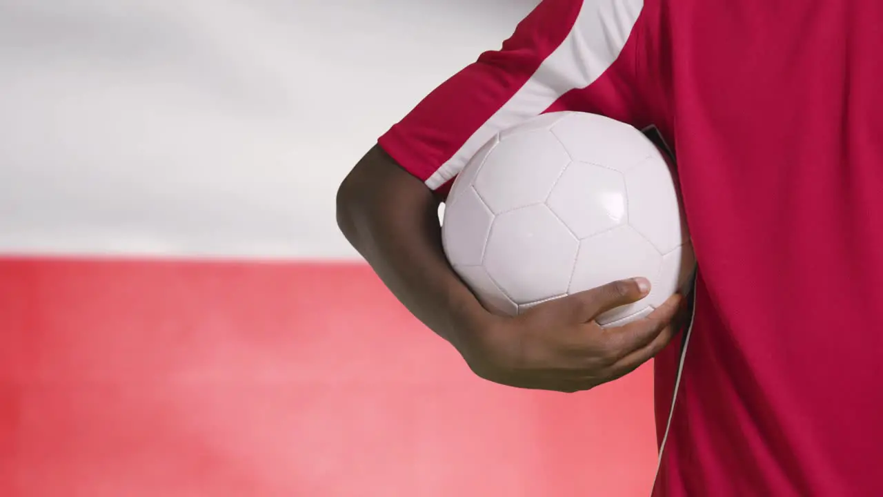 Young Footballer Walking Holding Football In Front of Poland Flag 01