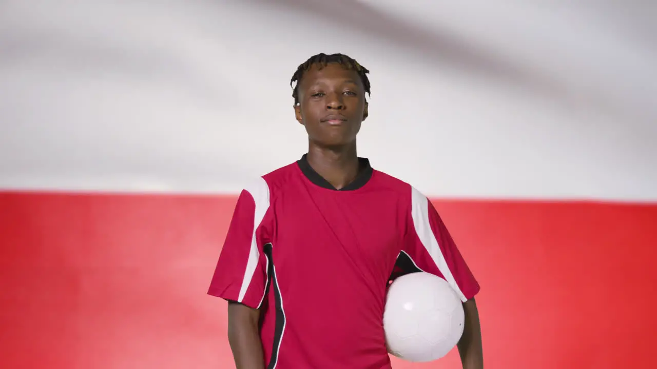 Young Footballer Walking Holding Football In Front of Poland Flag 02