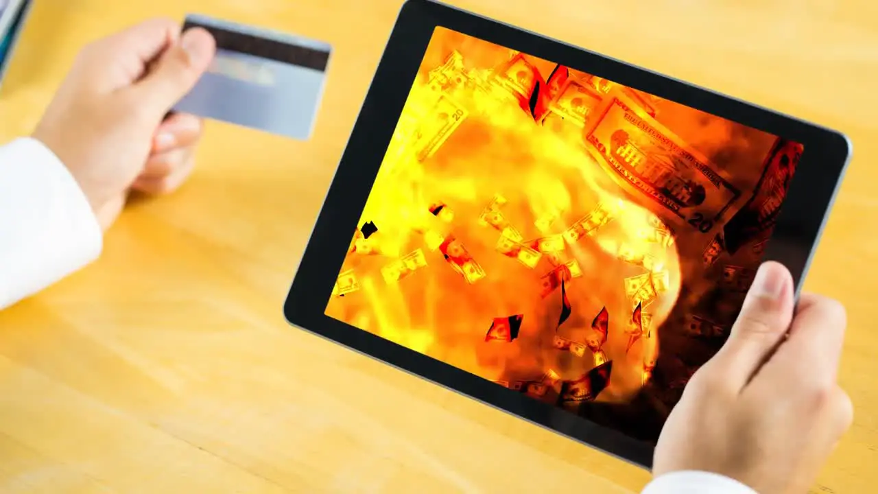 Digital animation of dollar bills falling on the fire flames in digital tablet