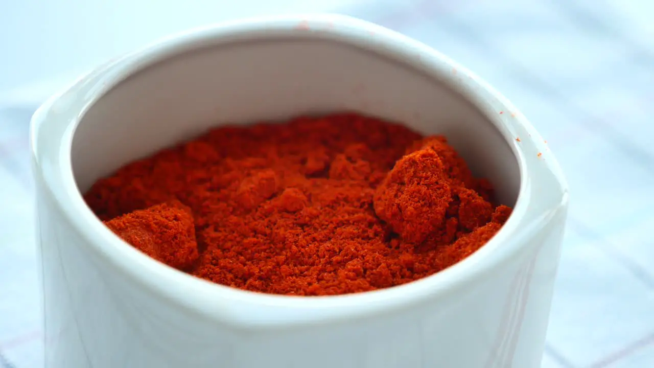 Chili powder and dried peppers on table background