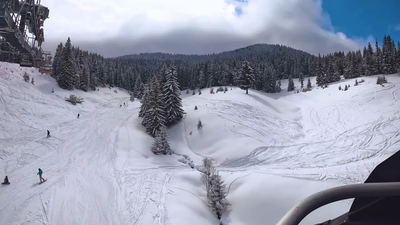 POV Shot Of Skier On Chair Lift Across Snow Covered Mountain And Trees 1