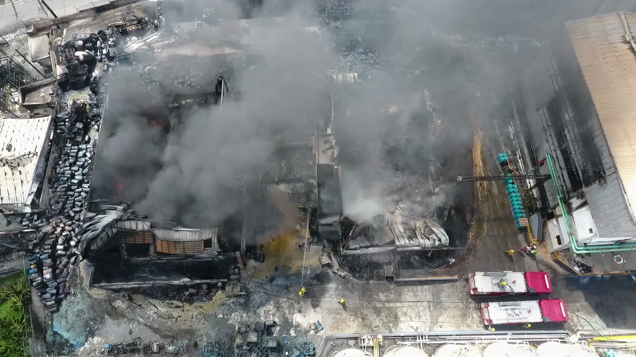 Aerial view overlooking firefighters extinguishing a house on fire sunny day in Port-Au-Prince Haiti tracking drone shot