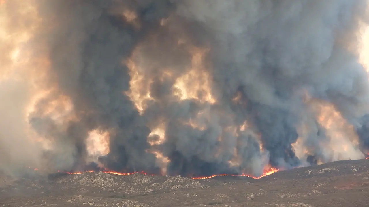 Mesmerizing view over a frightening wildfire with heavy black smoke rising