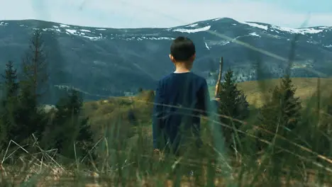 Outdoors family activity in wild environment Little boy walking across meadow