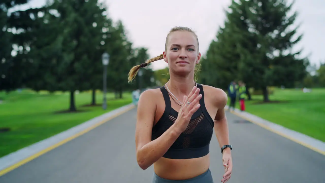 Happy athletic woman jogging in park Girl doing cardio workout outdoors