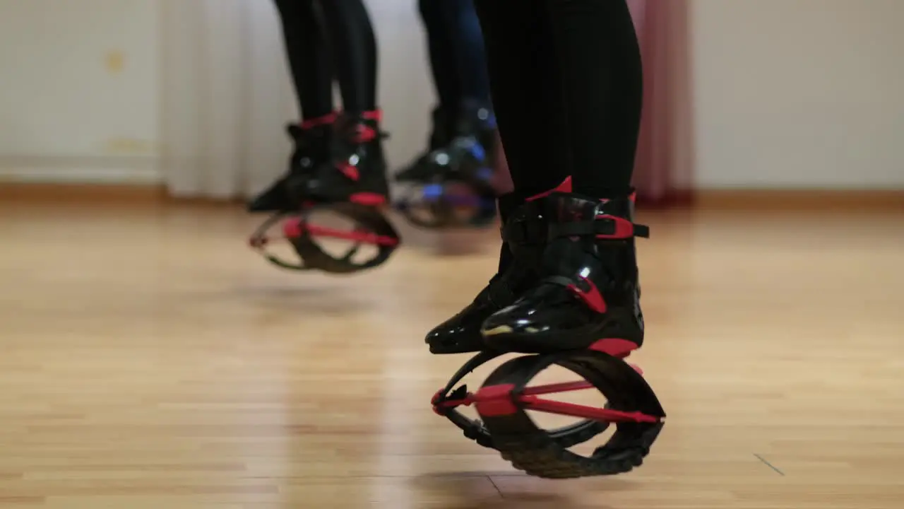 Women perform sports exercises in boots Кangoo jumps