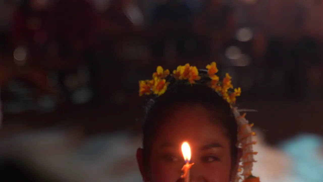 Close up view of female Thai dancers holding candles while performing dancers