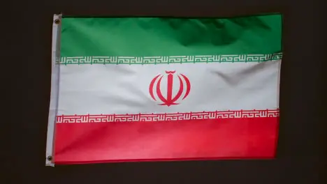 Studio Shot Of Flag Of Iran Flying Against Black Background