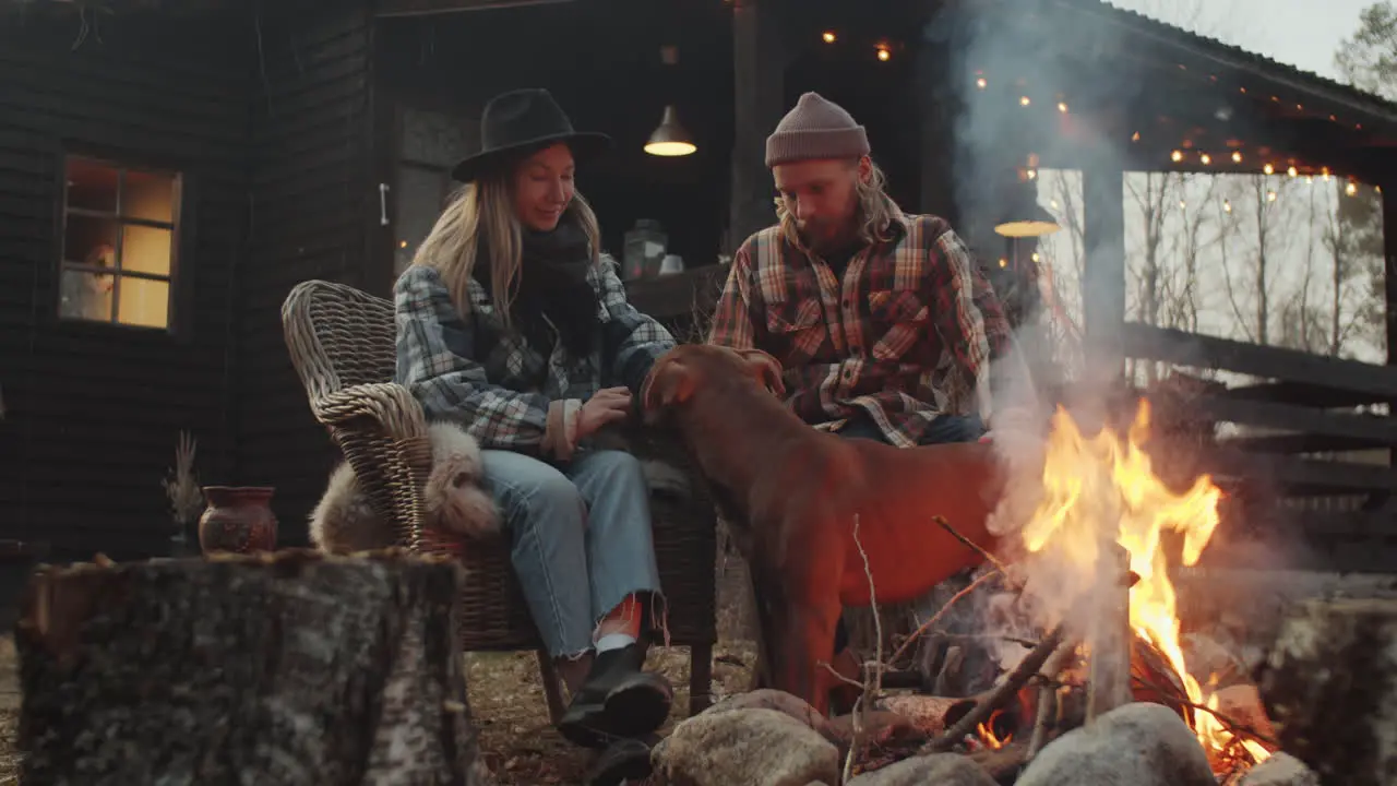 Couple Petting Dog by Bonfire