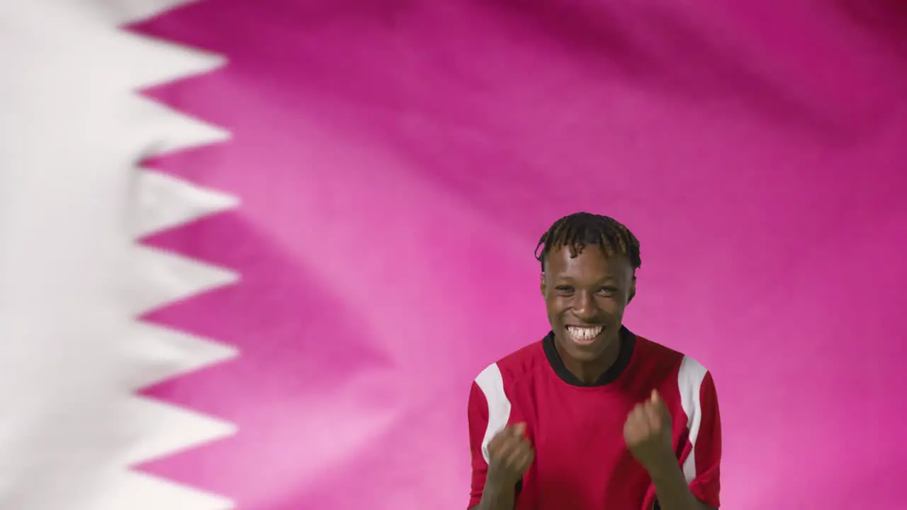 Young Footballer Celebrating to Camera In Front of Qatar Flag 01