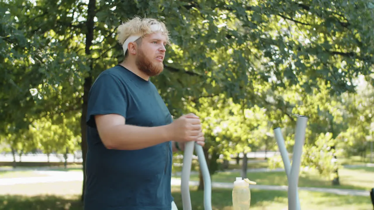 Obese Man Training on Walking Machine in Park