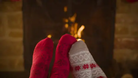 Close Up Shot of Couples Feet In Front of a Burning Fireplace