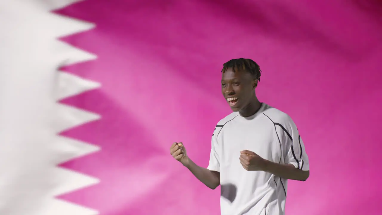 Young Footballer Celebrating to Camera In Front of Qatar Flag 02