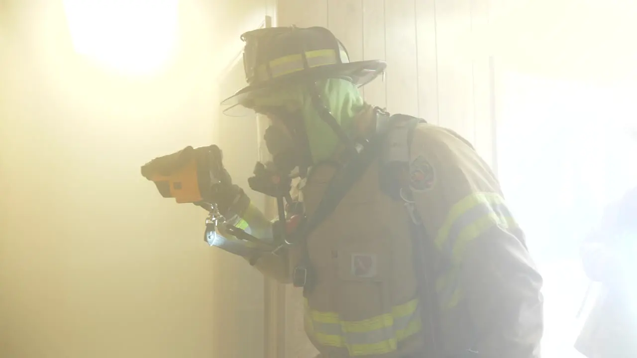 Firefighter uses an infrared thermal imager camera that senses body heat inside a smoky room