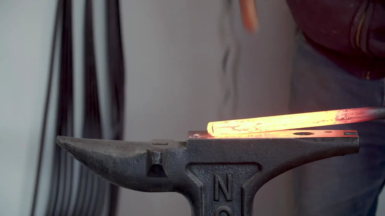 Blacksmith Hammering Red Hot Metal On An Anvil