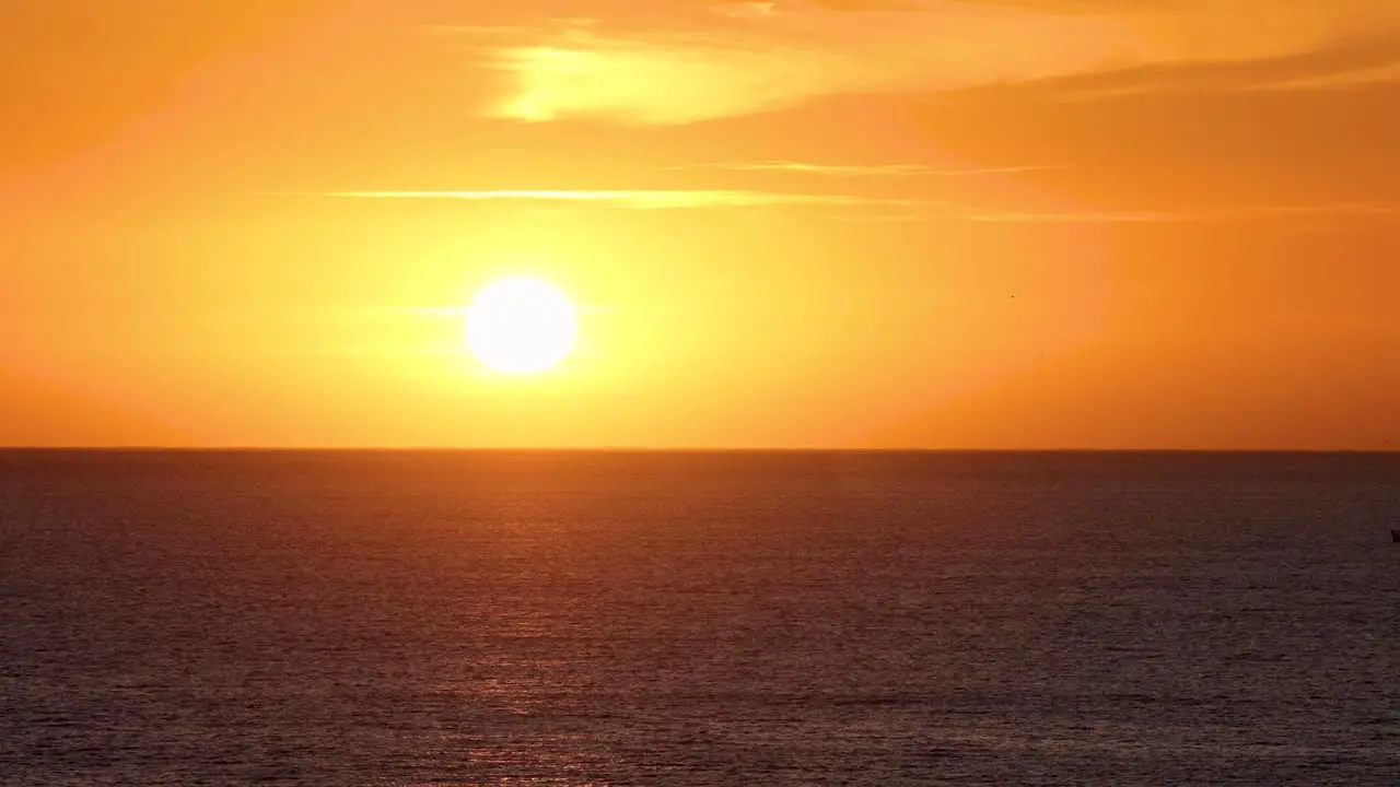 Orange sunset with sailboat on the ocean