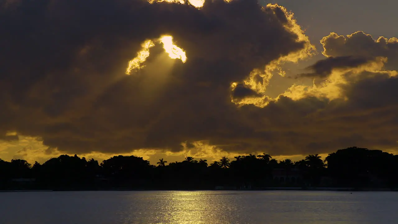 Golden Sun Streaming Through Hole In Clouds Over South Florida Water