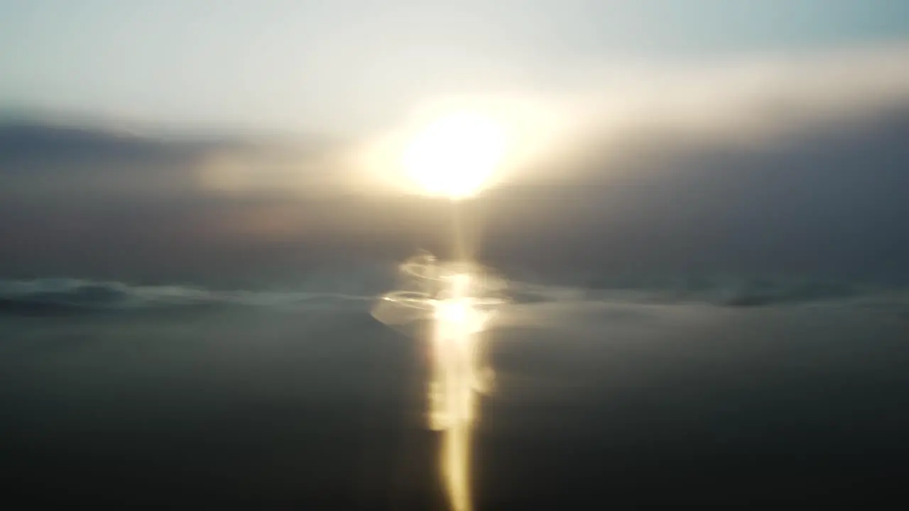 Floating on dark gloomy water surface facing sunset glow