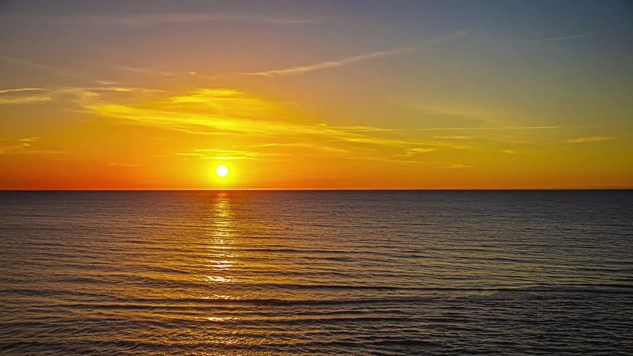 Time lapse of sun setting behind horizon over sea and ocean